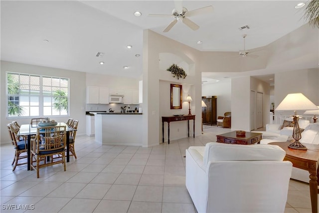 living area with recessed lighting, a high ceiling, and light tile patterned flooring