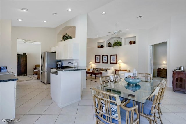 kitchen featuring a ceiling fan, dark countertops, freestanding refrigerator, and visible vents