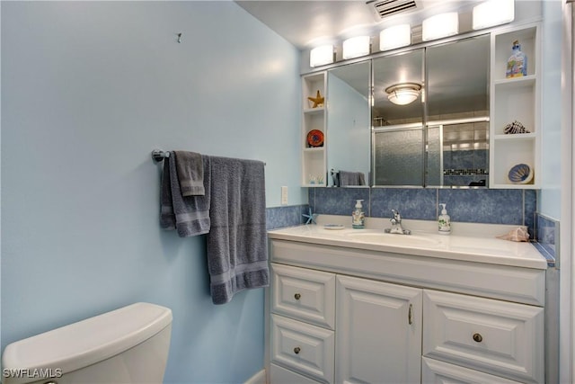 bathroom featuring vanity, a shower with shower door, and toilet