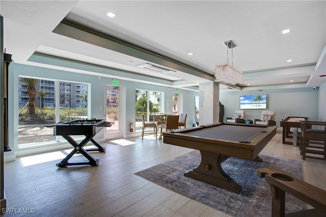 playroom featuring billiards, a raised ceiling, and light hardwood / wood-style floors