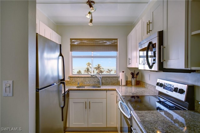 kitchen featuring light stone counters, sink, white cabinets, and appliances with stainless steel finishes