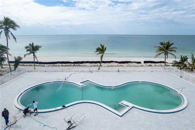 view of pool with a water view and a beach view