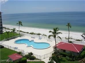 view of swimming pool with a view of the beach and a water view