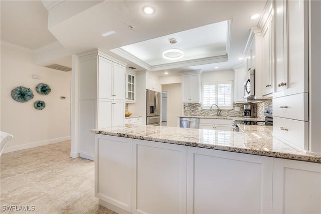 kitchen with light stone counters, white cabinetry, kitchen peninsula, and appliances with stainless steel finishes