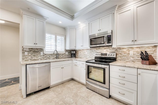 kitchen featuring white cabinetry, crown molding, tasteful backsplash, and stainless steel appliances