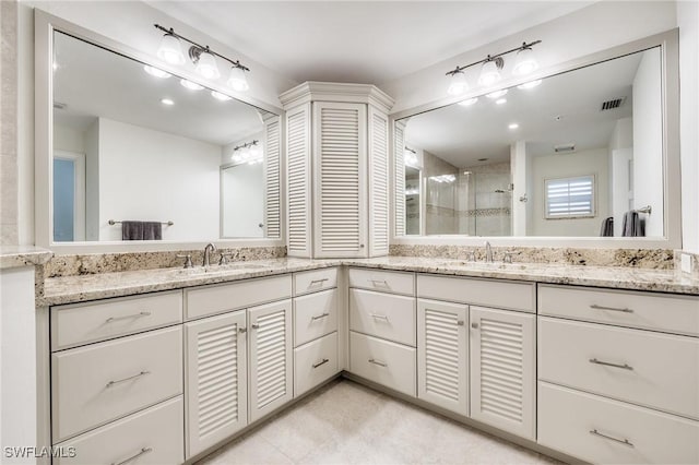 bathroom with vanity and a shower with door