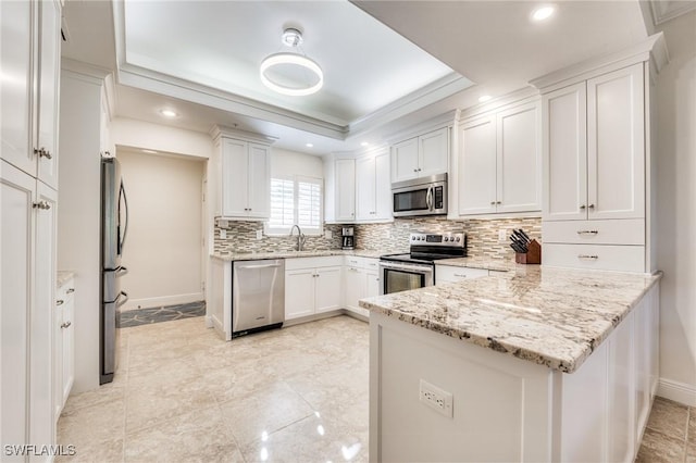 kitchen featuring white cabinetry, appliances with stainless steel finishes, sink, and light stone counters