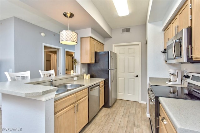 kitchen featuring pendant lighting, light hardwood / wood-style floors, kitchen peninsula, stainless steel appliances, and light brown cabinets