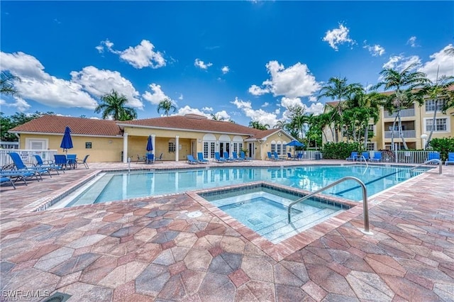 view of swimming pool with a hot tub and a patio