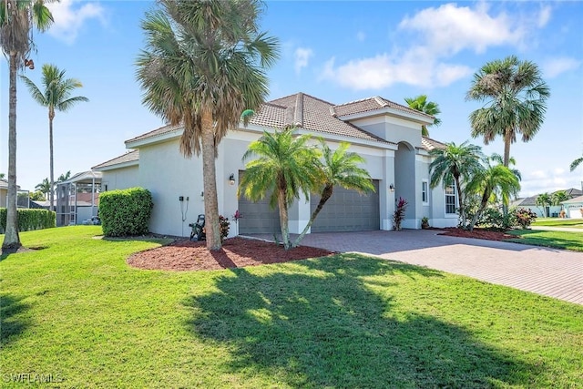 mediterranean / spanish-style home with a garage and a front lawn