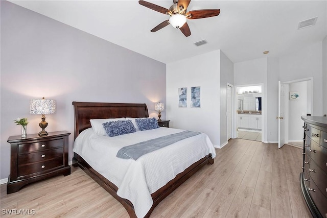 bedroom featuring ceiling fan, ensuite bathroom, and light wood-type flooring