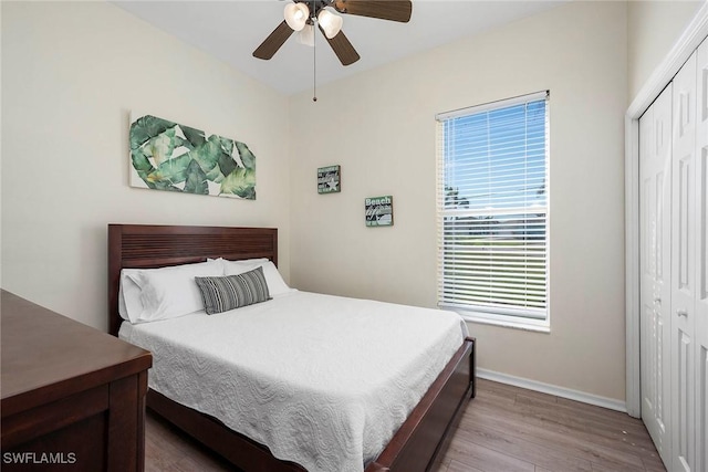 bedroom with a closet, ceiling fan, and light wood-type flooring