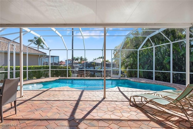 view of swimming pool featuring a patio, pool water feature, and glass enclosure