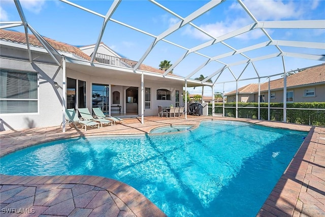 view of swimming pool with an in ground hot tub, a lanai, and a patio area