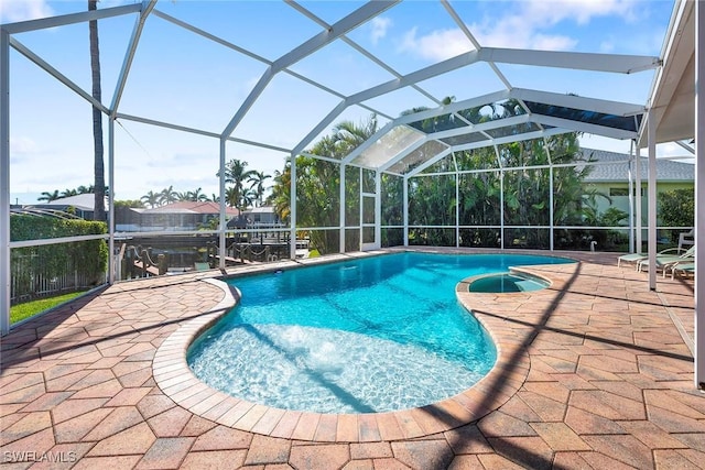 view of pool with a patio area and glass enclosure