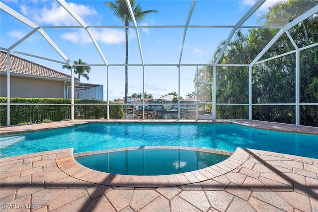 view of swimming pool featuring a lanai and a patio area