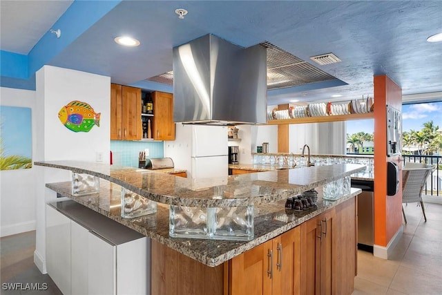 kitchen featuring tasteful backsplash, island range hood, stainless steel dishwasher, white fridge, and dark stone counters