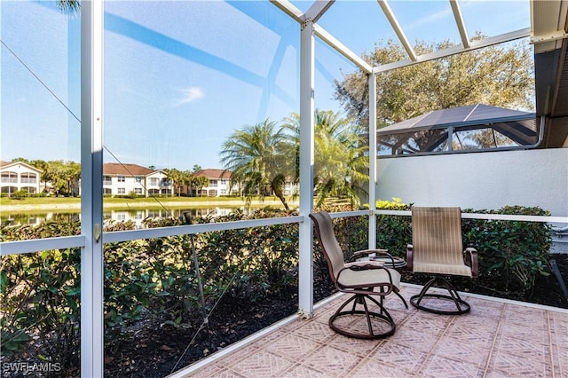 sunroom featuring a water view