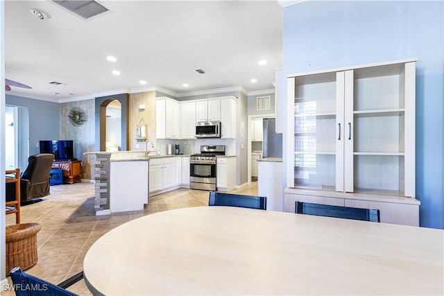 interior space with sink, ornamental molding, and a healthy amount of sunlight