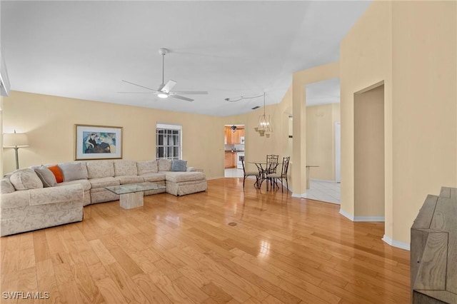 living room with ceiling fan and light wood-type flooring