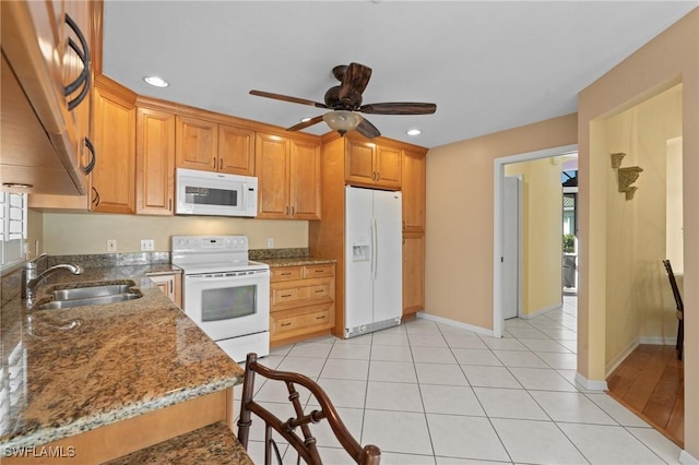 kitchen with stone countertops, sink, light tile patterned floors, ceiling fan, and white appliances