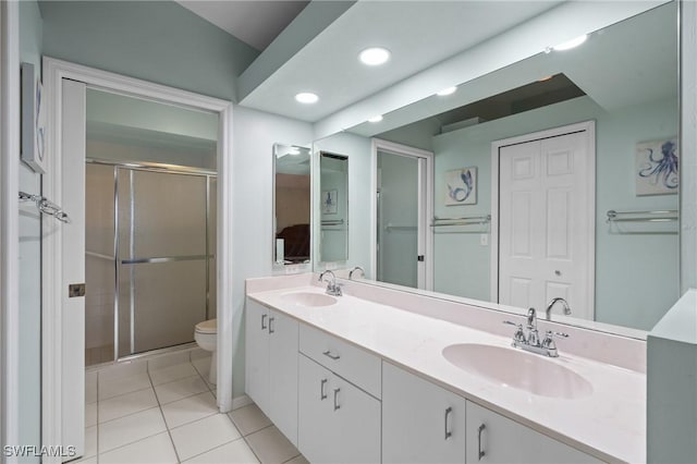 bathroom with tile patterned floors, vanity, toilet, and a shower with shower door