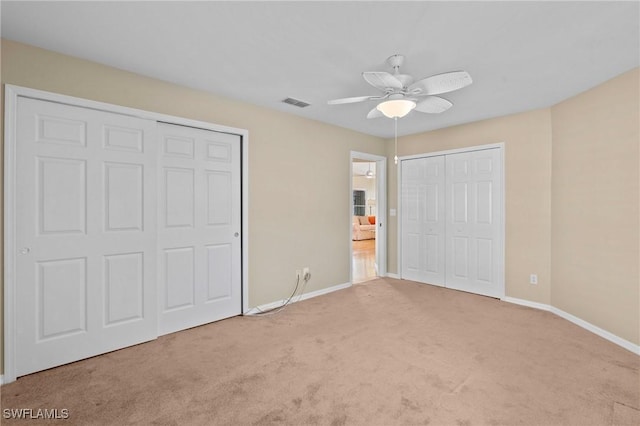 unfurnished bedroom featuring ceiling fan and light colored carpet