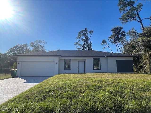 single story home featuring a garage and a front lawn