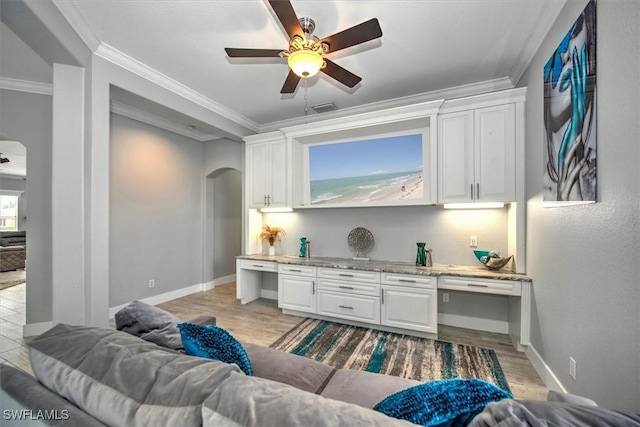 living room with built in desk, ornamental molding, light hardwood / wood-style floors, and ceiling fan