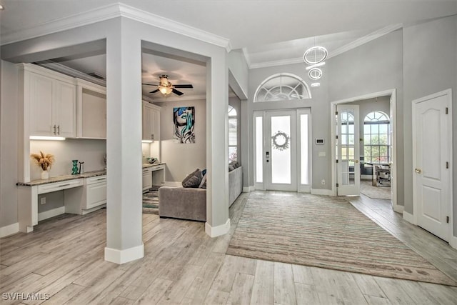 foyer with crown molding and light wood-type flooring