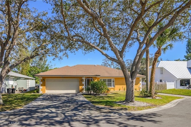 single story home with aphalt driveway, an attached garage, fence, stucco siding, and a front yard