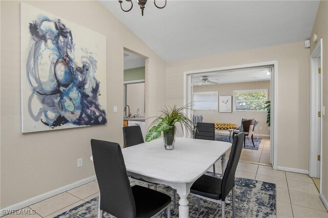 dining area featuring lofted ceiling, light tile patterned floors, sink, and ceiling fan