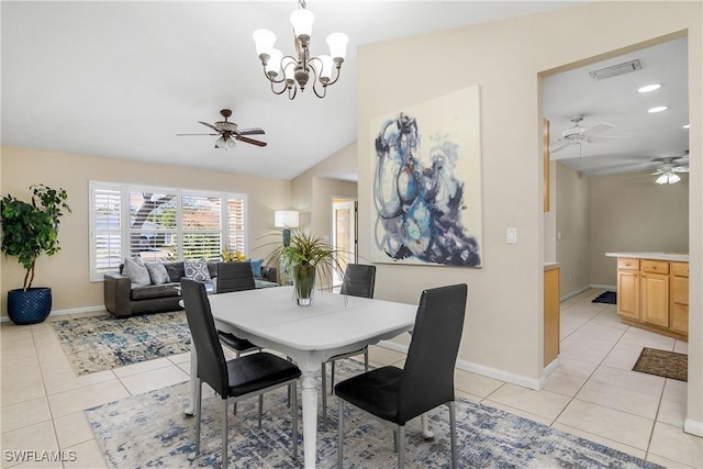 dining space with light tile patterned flooring, vaulted ceiling, and ceiling fan with notable chandelier