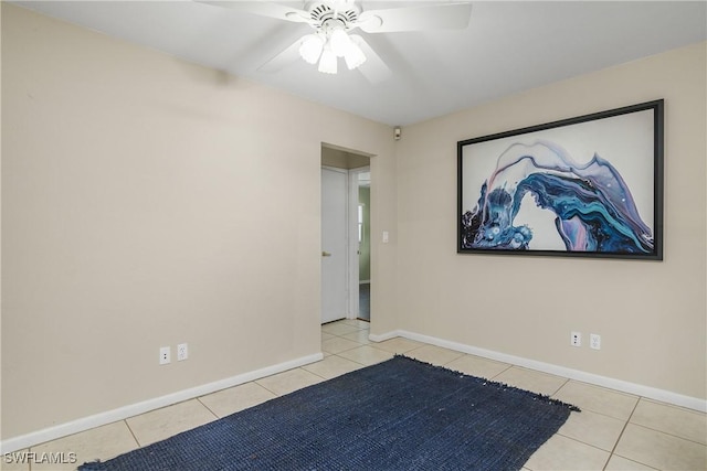 tiled empty room featuring ceiling fan