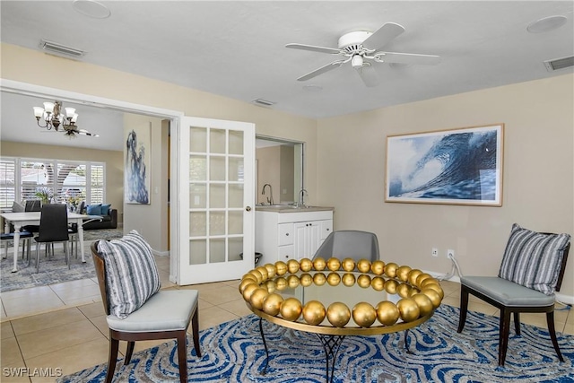 sitting room featuring light tile patterned floors, ceiling fan with notable chandelier, sink, and french doors