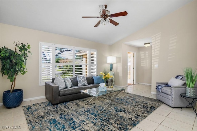 living area with tile patterned flooring, baseboards, ceiling fan, and vaulted ceiling