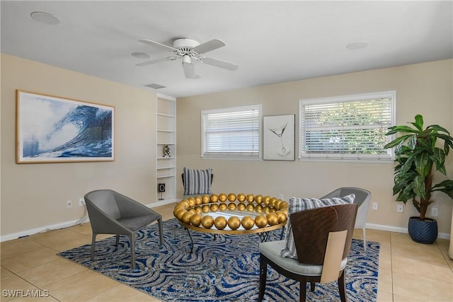 living area featuring built in shelves, a ceiling fan, baseboards, light tile patterned floors, and visible vents