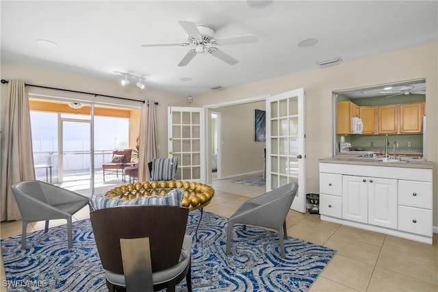 interior space with a ceiling fan, french doors, visible vents, and light tile patterned floors