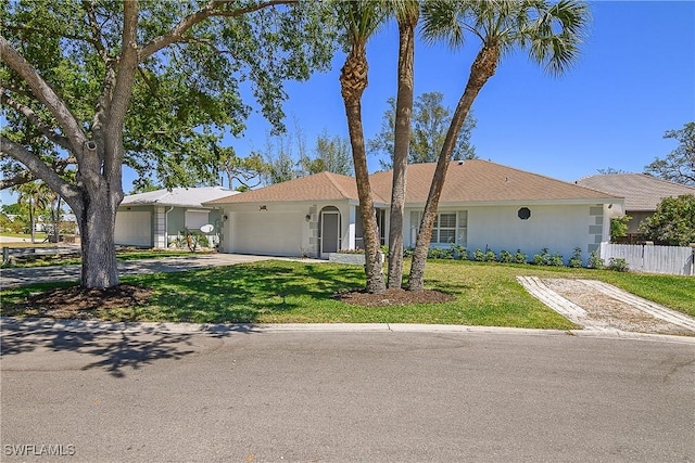 single story home featuring fence, an attached garage, concrete driveway, and a front yard