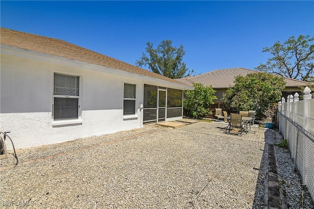 rear view of house with a fenced backyard, a patio, and stucco siding