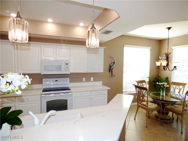 kitchen with white cabinetry, white appliances, decorative light fixtures, and a notable chandelier