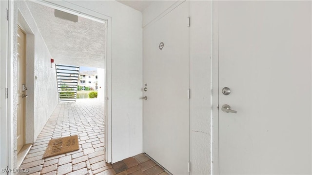 doorway featuring a textured ceiling