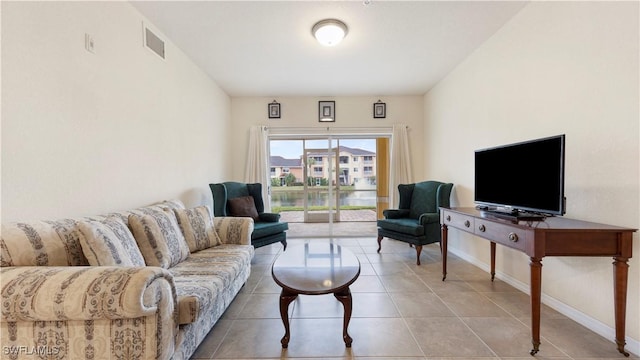 living room with tile patterned flooring, visible vents, and baseboards