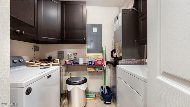 clothes washing area with electric panel, cabinet space, and washer and clothes dryer