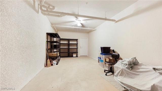 office featuring a ceiling fan, concrete flooring, and a textured wall