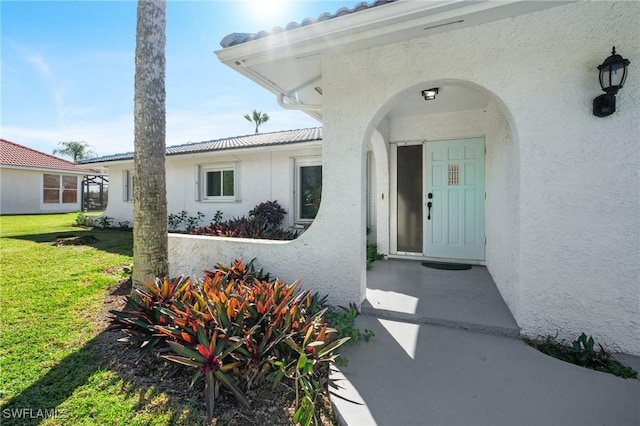 entrance to property featuring a lawn