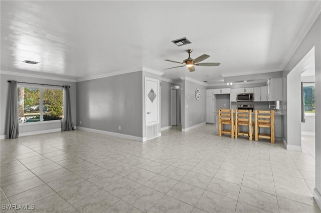 unfurnished living room featuring ceiling fan, ornamental molding, and light tile patterned floors