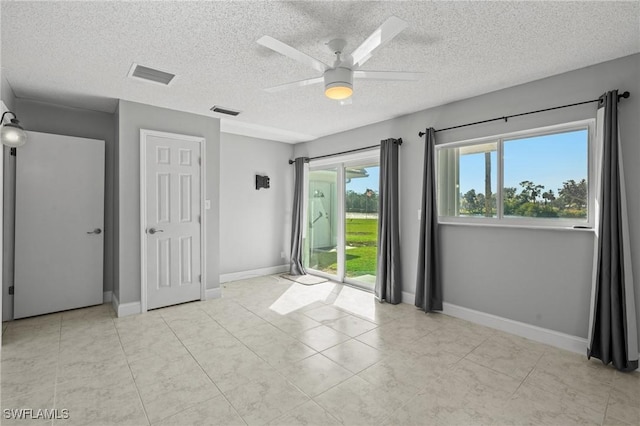 spare room featuring a textured ceiling and ceiling fan