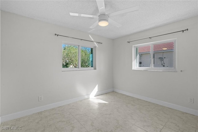 empty room with ceiling fan and a textured ceiling