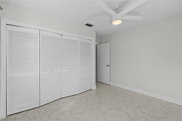 unfurnished bedroom with ceiling fan and a closet